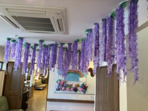 紫色の藤の花で装飾された共用スペース。天井から吊るされたデコレーション。